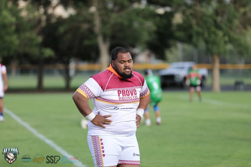 Provo Broncos player in white and maroon jersey standing with hands on hips on the field