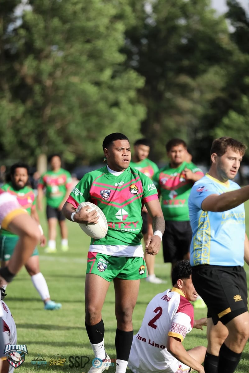 Rabbitahz player in green carries the ball back with the referee in blue behind