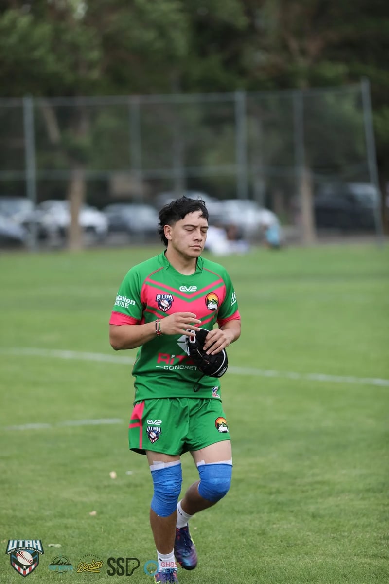 Rabbitahz player in green and red adjusts his hand strapping on the field