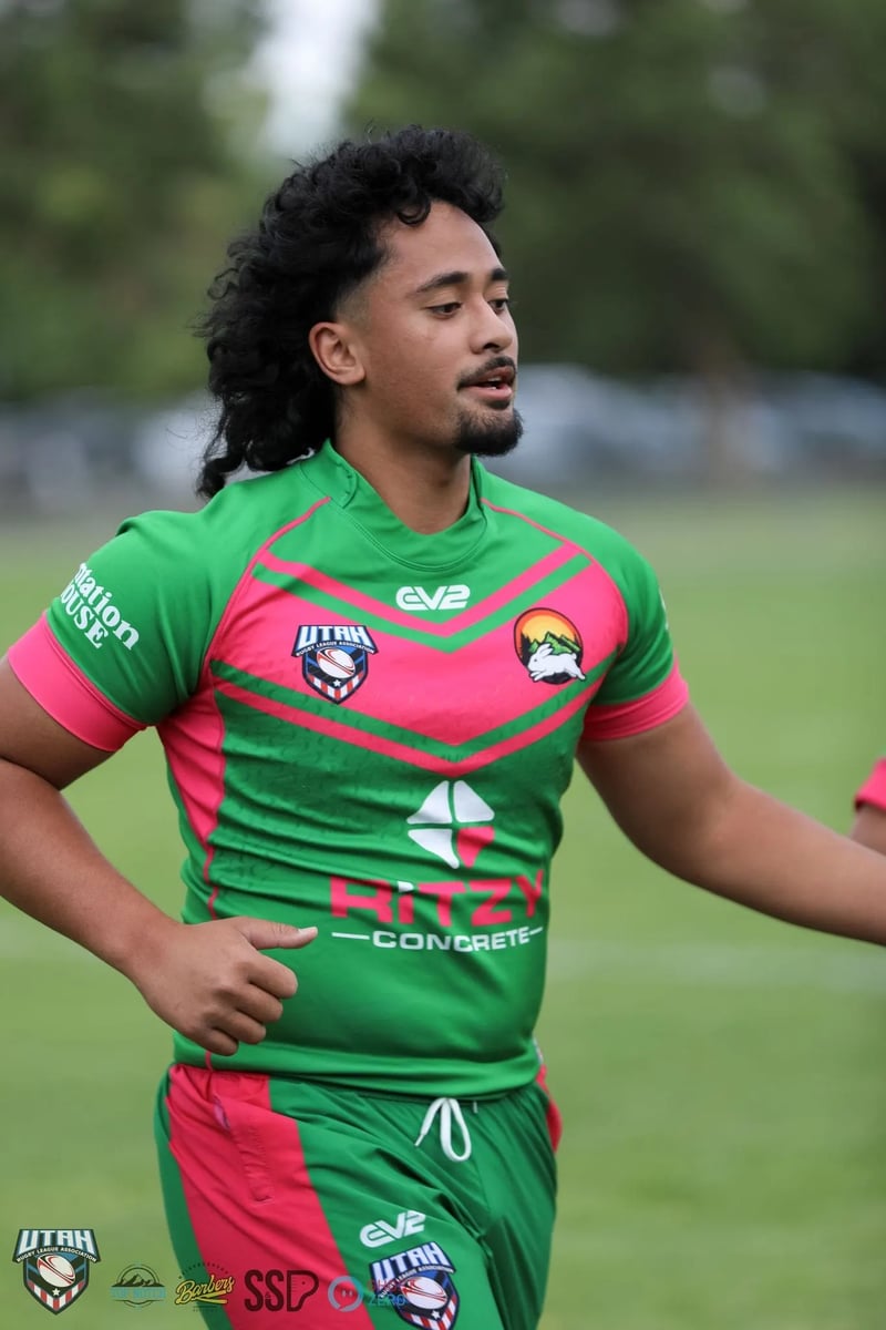 Rabbitahz player stands hands-on-hips in green and red jersey catching his breath