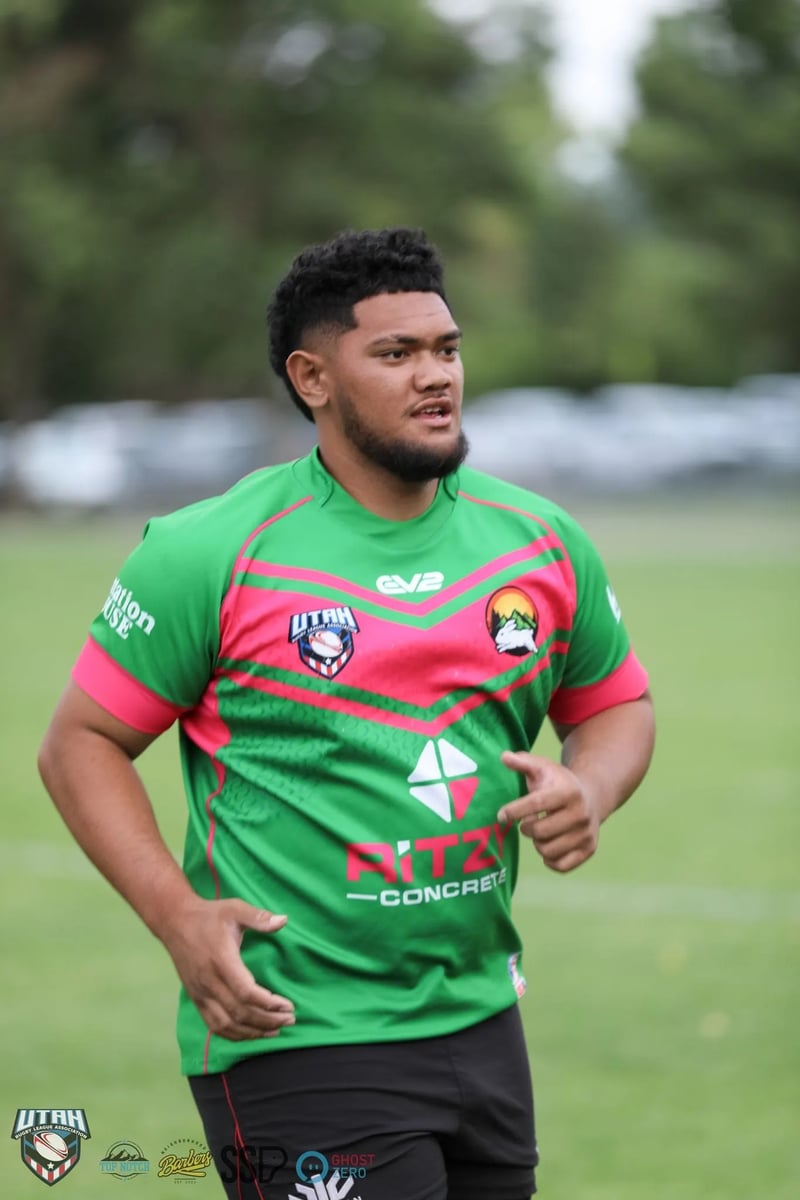 Rabbitahz player in green and red jersey stands on the field, arms relaxed