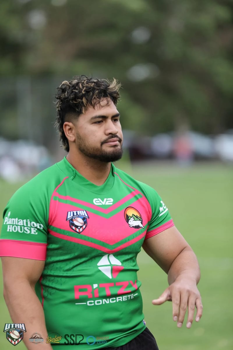 Rabbitahz player with a mullet looks down pensively in green and red jersey