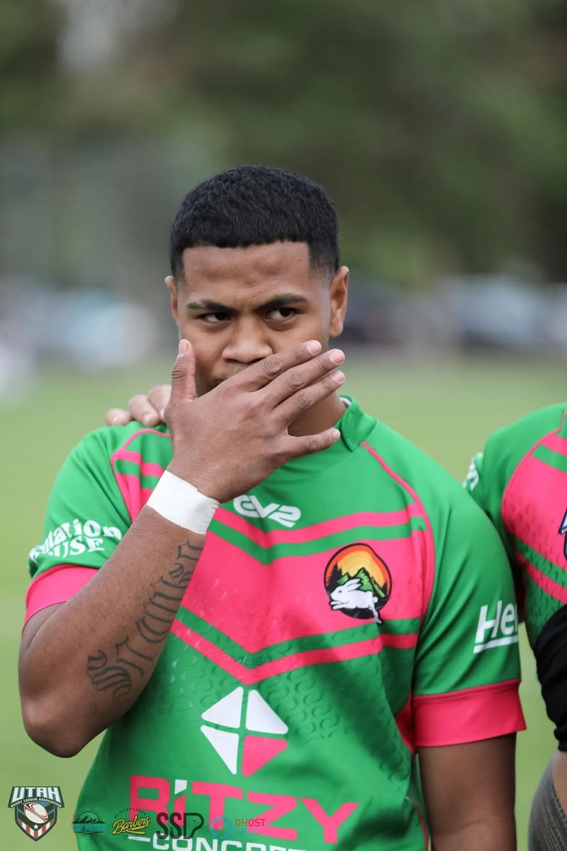 Rabbitahz player covers his mouth with a taped hand while listening in the huddle