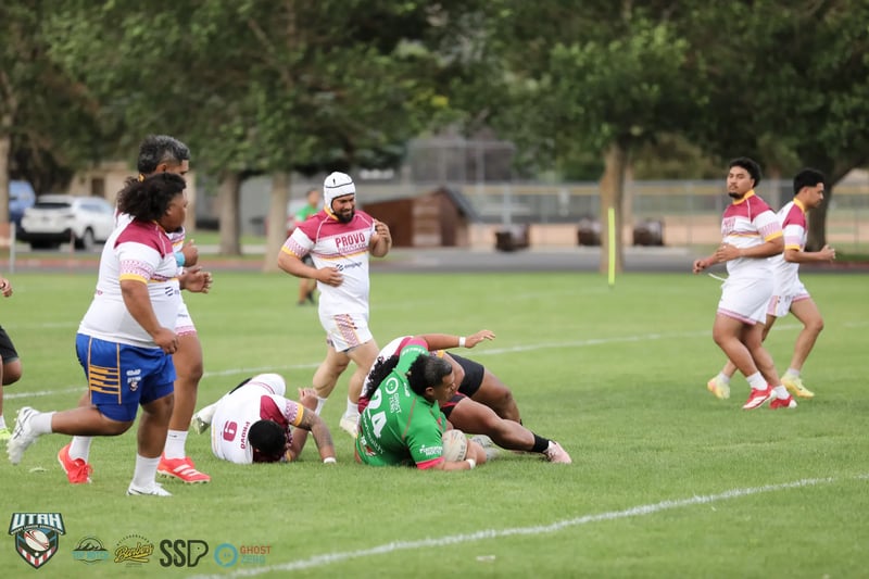 Provo Broncos forwards in white and maroon work over the ball at a ruck as Bluffdale Rabbitahz players in green contest possession.