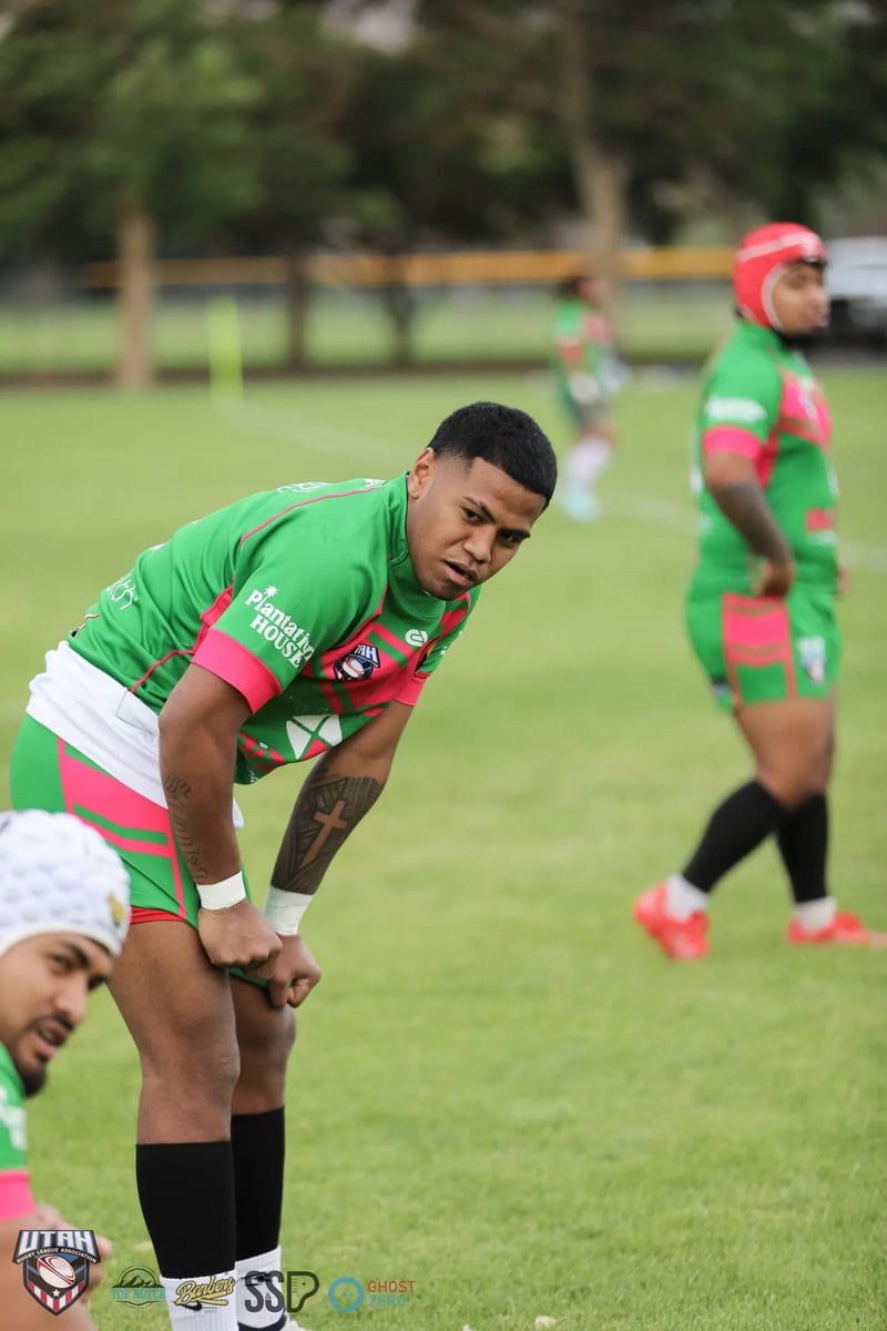 Rabbitahz player in green and red crouched with hands on knees waiting in the defensive line