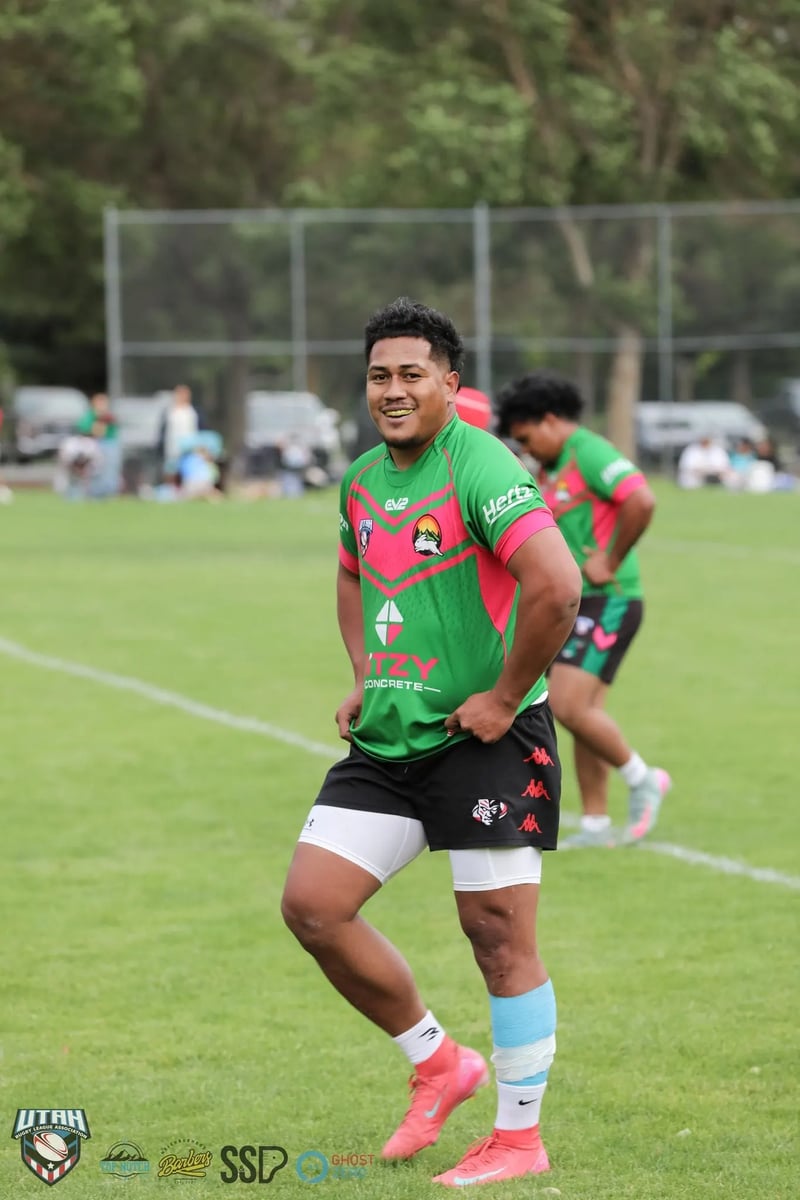 Smiling Rabbitahz forward in a green and red jersey walks off the field adjusting his shirt