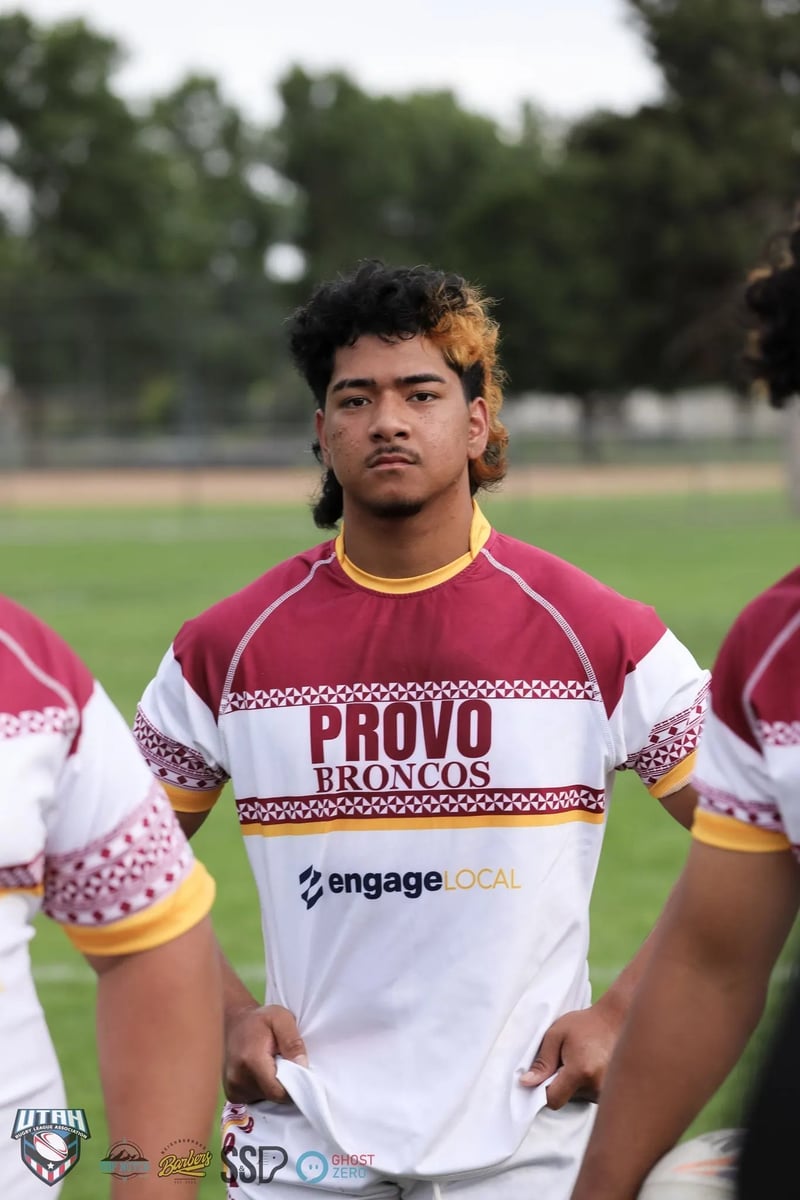 Close-up of a young Provo Broncos player in a maroon and white hooped jersey looking straight ahead