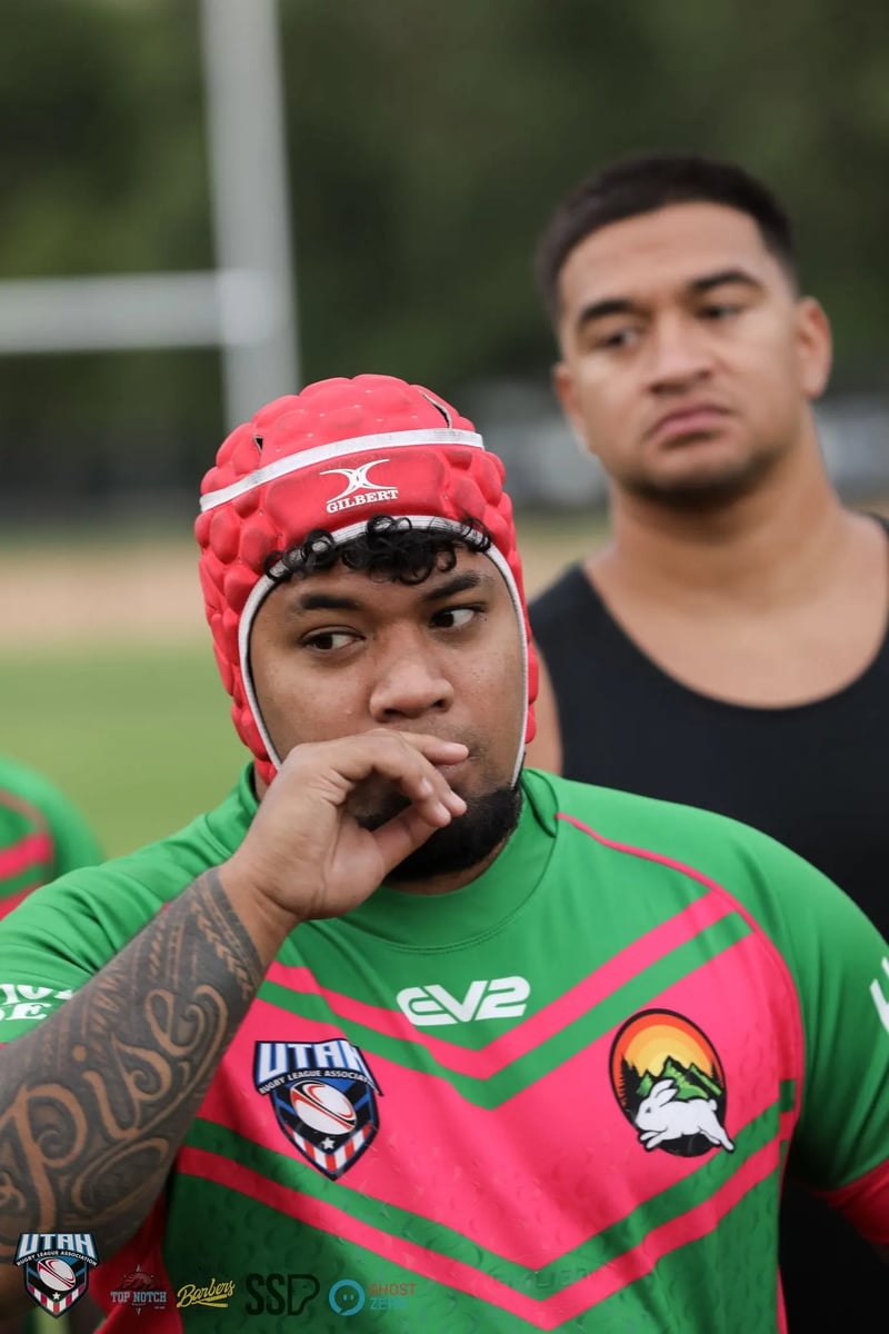 Rabbitahz player in a red scrum cap stands in thought with a hand to his mouth before kickoff