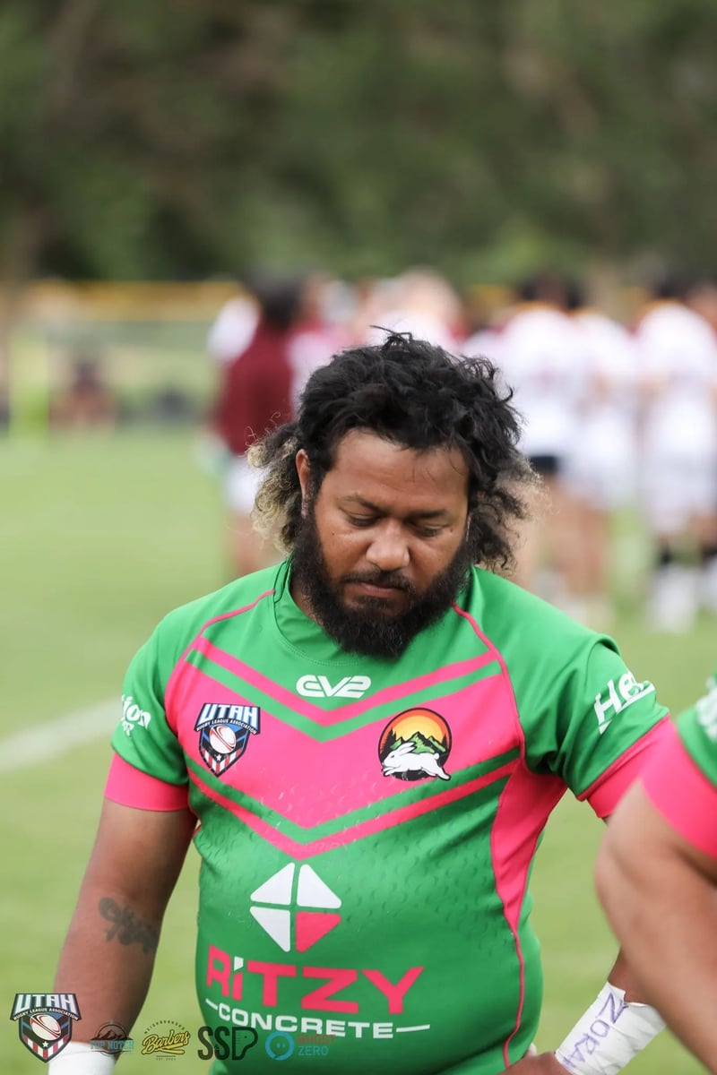 Bearded Rabbitahz player in a green and red jersey bows his head in a quiet pre-game moment