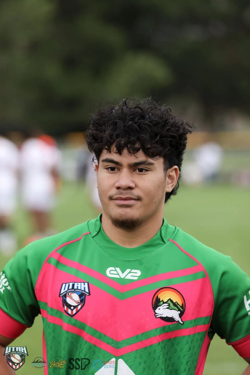 Young Rabbitahz player in a green jersey with curly hair looks toward the camera against a soft green background