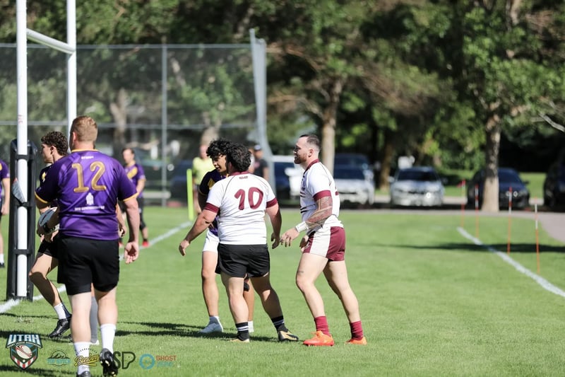 Players in purple and gold exchange handshakes with white-and-maroon opponents near the posts after a score
