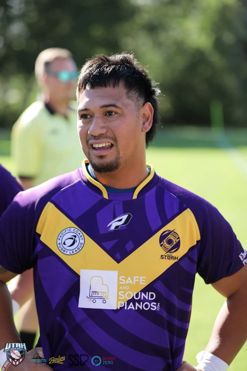 Smiling Raiders player in a purple and gold jersey during a break in play