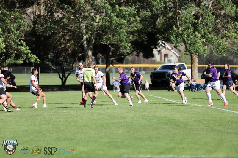 Open play spreads across the park as the referee tracks the Seagulls and Raiders through midfield.