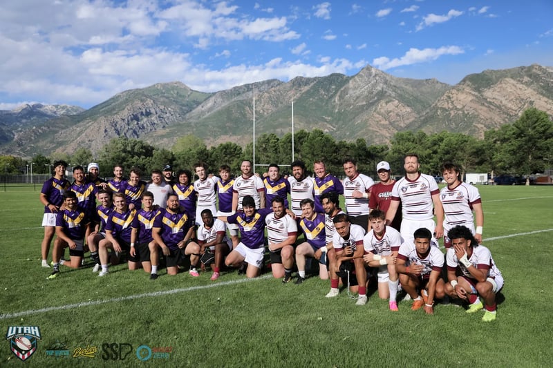 The Riverton Seagulls and Lehi Raiders squads pose together after the preseason opener with the Wasatch mountains behind them.