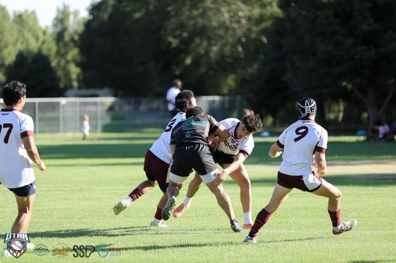 Three Seagulls defenders in white and maroon converge to wrap up a Rabbitahz ball-carrier wearing headgear.