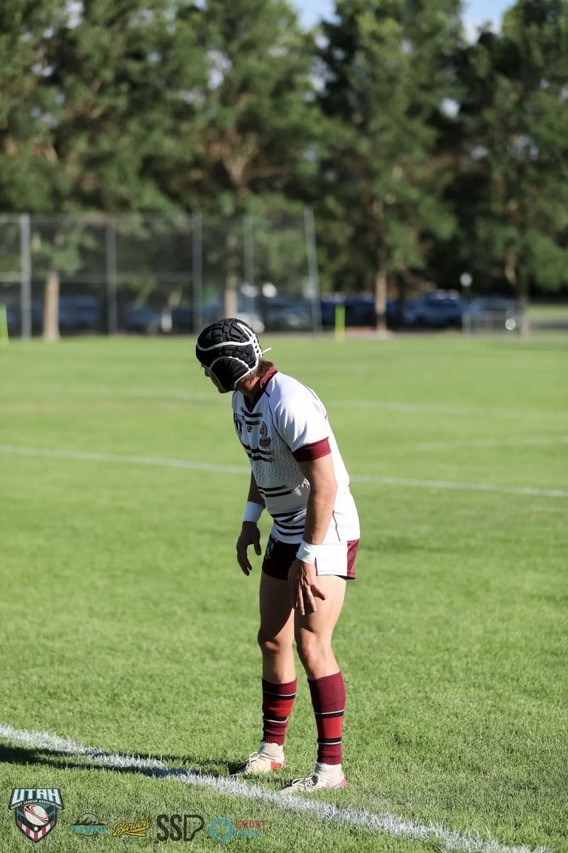 Seagulls player in white and maroon with black headgear stands catching his breath between plays.