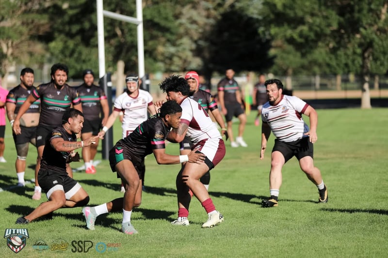 Rabbitahz defenders in black meet a Seagulls ball-carrier in white and maroon in a heavy midfield collision with support players closing in.