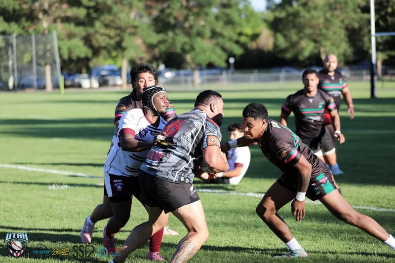 Peak-contact tackle as a Seagulls carrier in white and maroon is wrapped up by two Rabbitahz defenders in dark green-and-red-trimmed kit.