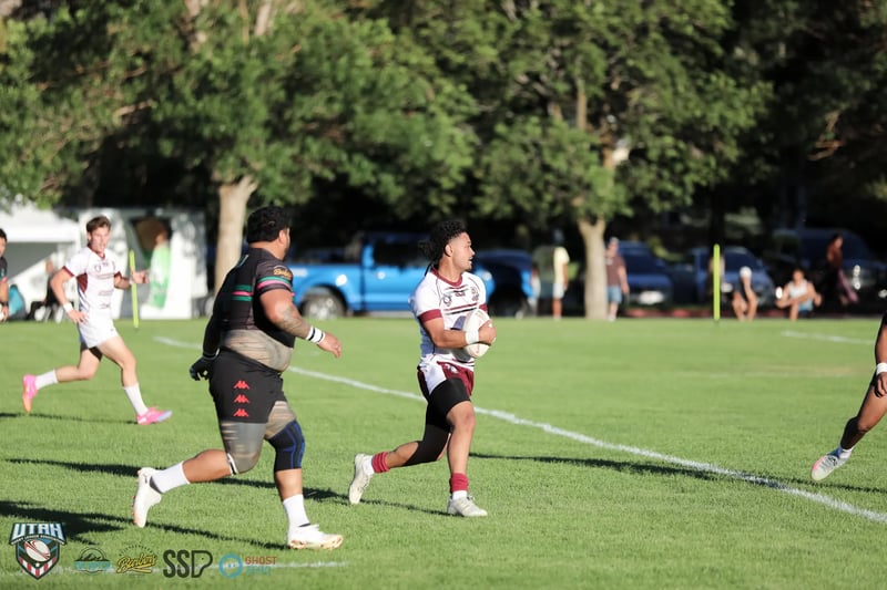 A Bluffdale Rabbitahz ballcarrier runs upfield as a Riverton Seagulls defender covers across.
