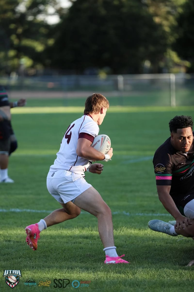 A Seagulls back in white and maroon carries the ball at pace as a Rabbitahz defender in dark kit looms in the foreground.
