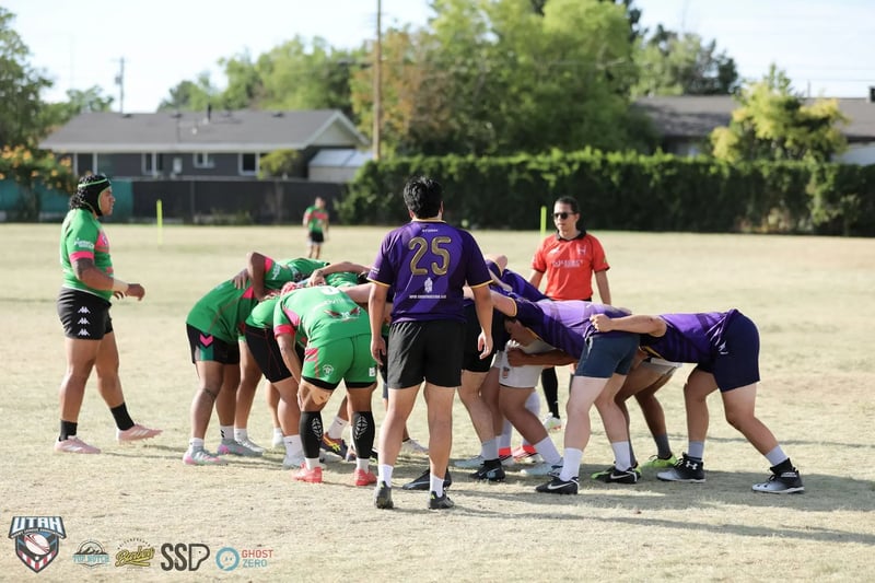 The packs bind for a scrum, Rabbitahz forwards in green and red against Raiders forwards in purple, with the number 25 halfback standing over the feed and an official in orange watching on.