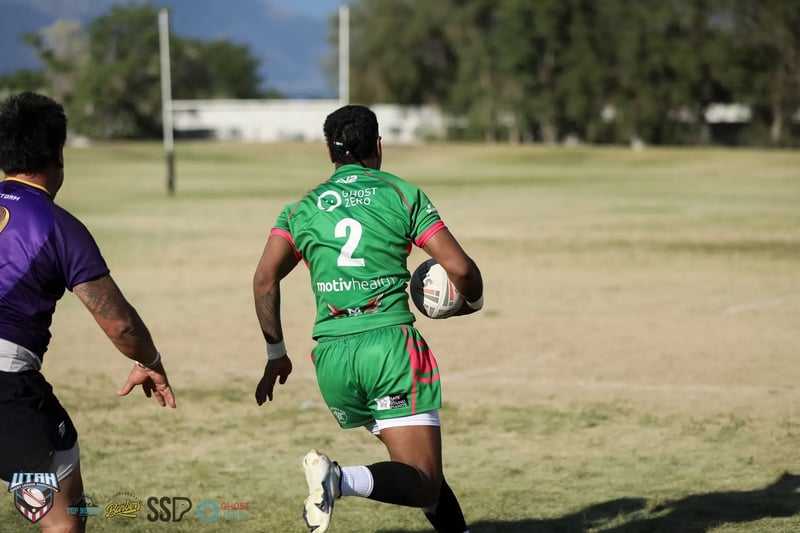 Rabbitahz number 2 in green and red races toward the goalposts with the ball, wide open field ahead of him