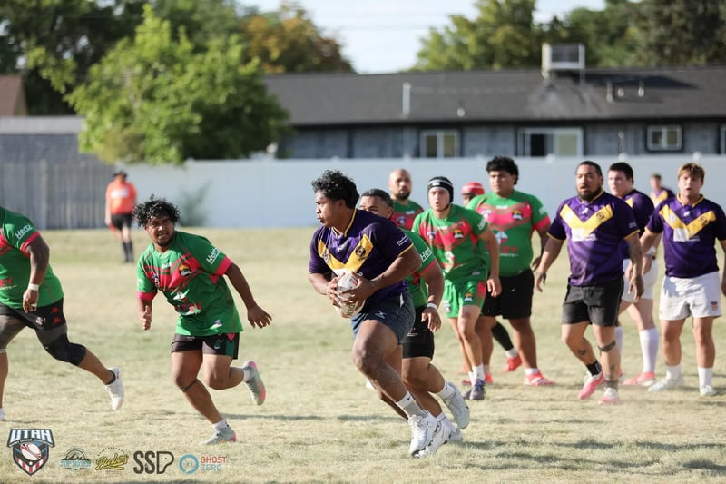 Raiders ball carrier in purple and gold takes the ball into a swarm of Rabbitahz defenders in green and red