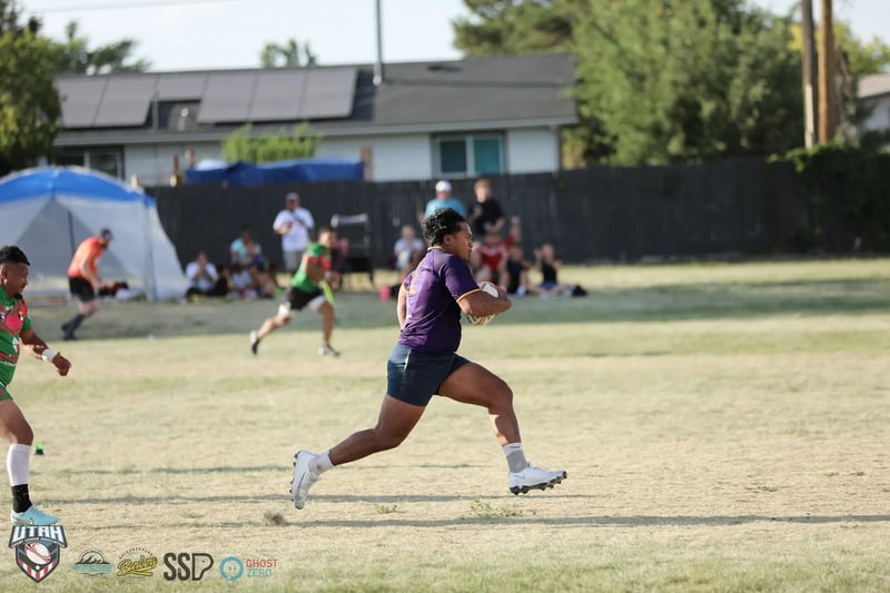 A Lehi Raiders ballcarrier in purple sprints down the touchline past the festival tents at South Ridge Park.