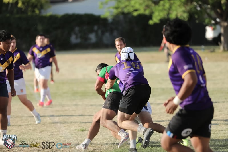 A Lehi Raiders ballcarrier in purple is wrapped up by Bluffdale Rabbitahz defenders in green.