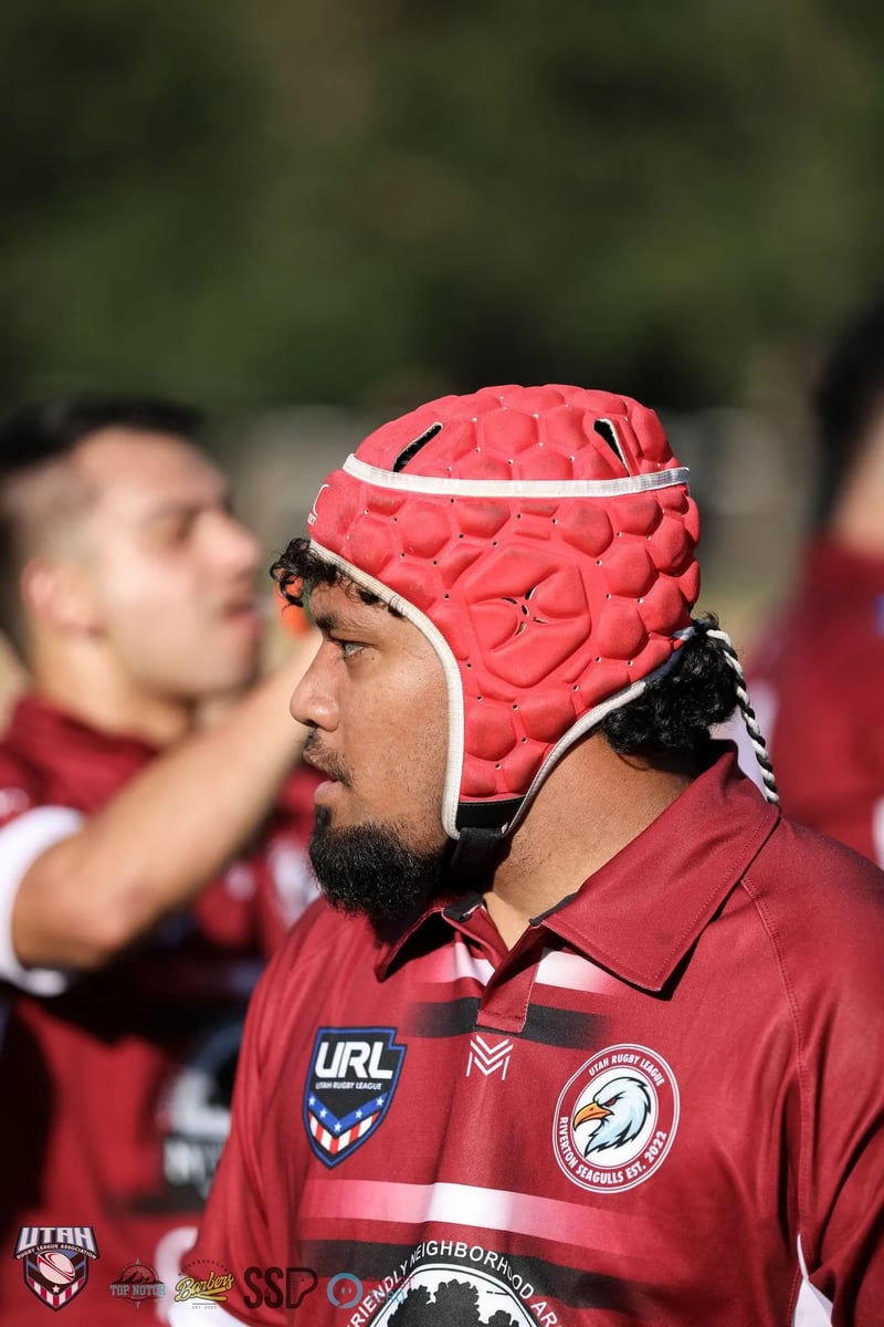 A Riverton Seagulls forward in a red scrum cap on the sideline.
