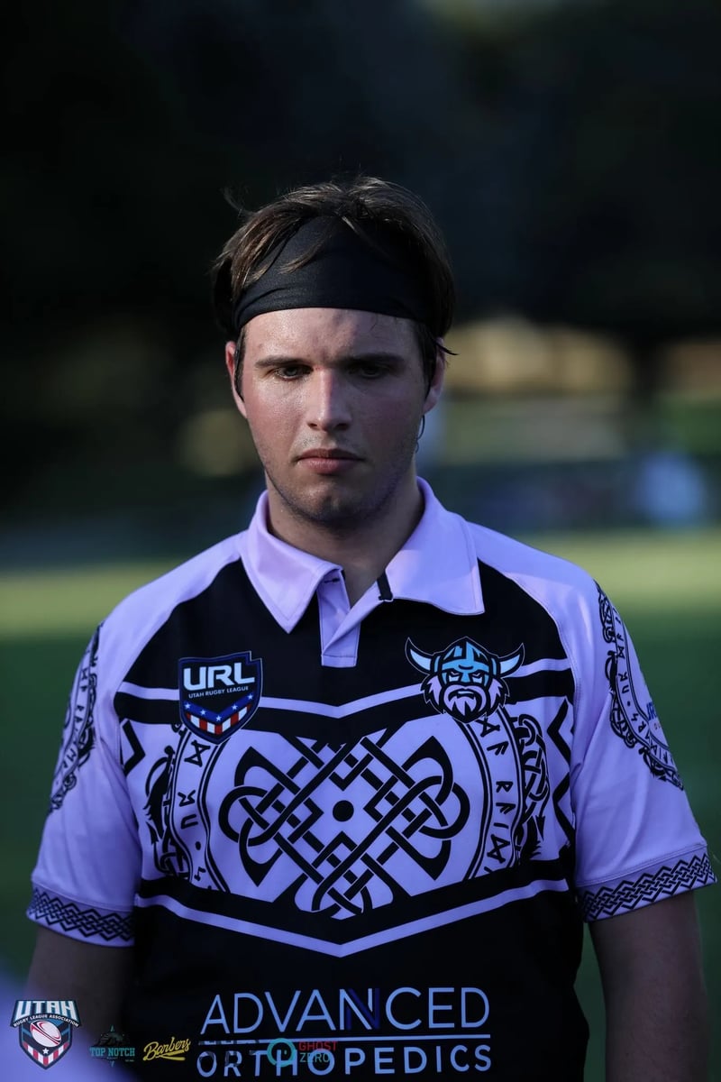A Lehi Raiders player in a black headband looks out across the field.
