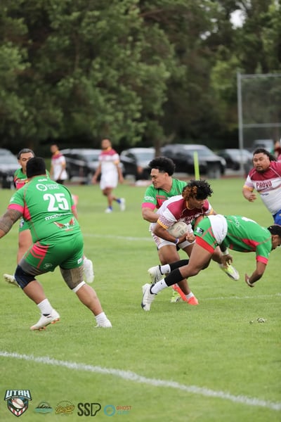 Broncos ball carrier bursts through the line between Rabbitahz defenders with a teammate giving chase