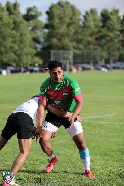 Broncos tackler in white drives front-on into a Rabbitahz ball carrier at close quarters