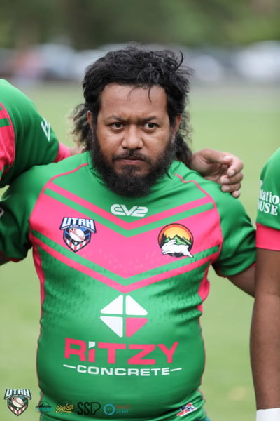 Bearded Rabbitahz player links arms with teammates in a tight pre-game huddle
