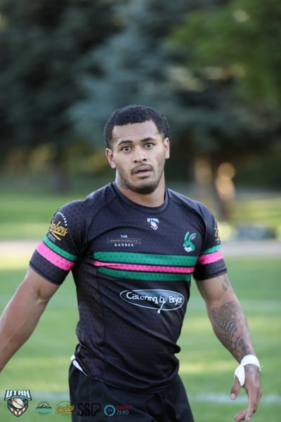 Close portrait of a Bluffdale Rabbitahz player in a black jersey with green and red hoops, looking toward the camera between plays.