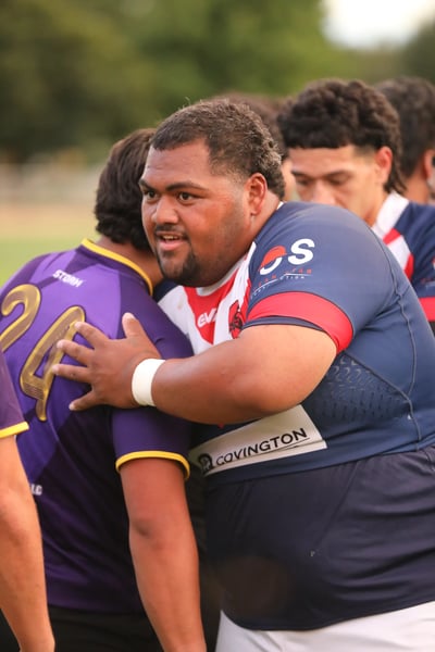 Roosters player with an arm around a Raiders opponent during a break in play
