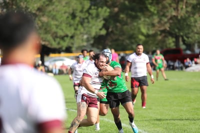 Seagulls ball carrier in white and maroon taking contact from a Rabbitahz defender in green