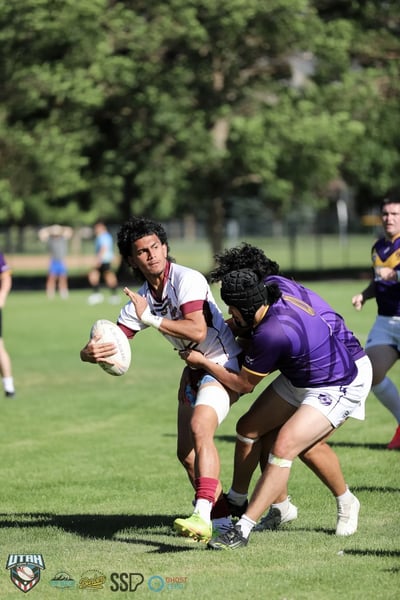 A Seagulls ball carrier tucks the ball and braces as a Raiders defender wraps him up