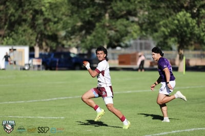 A Seagulls ball carrier sprints upfield at full stride with a Raiders chaser trailing