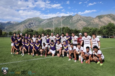 Both squads pose together for a post-match group photo under blue sky and mountains after the preseason match