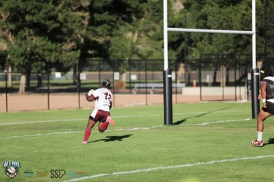 Seagulls number 12 in white and maroon sprints through open space toward the goal posts on a try-scoring run.
